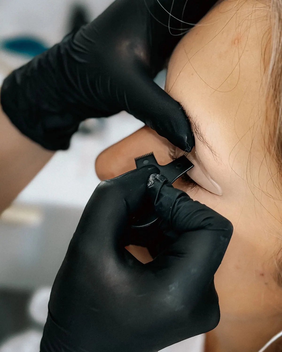 Microblading kalemiyle kas uygulamasi yapan eldivenli eller